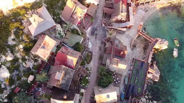 Wooden village on Mediterranean sea coastline, aerial top down view