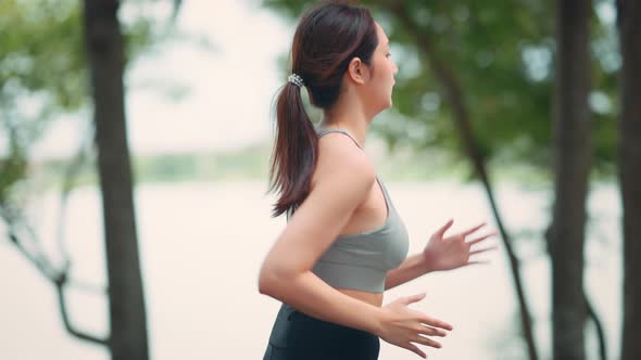 Runner young woman running in the summer park