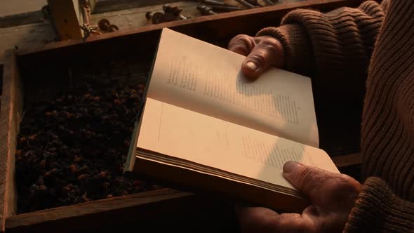 Man Glasses Picks Up Old Book in Dust Read in House Window