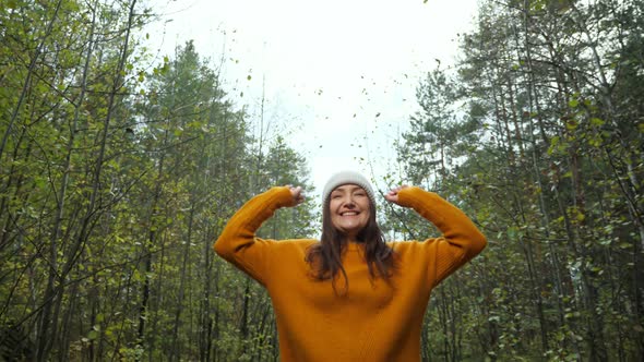 Positive Woman in Hat Raises Hands Spending Time in Forest