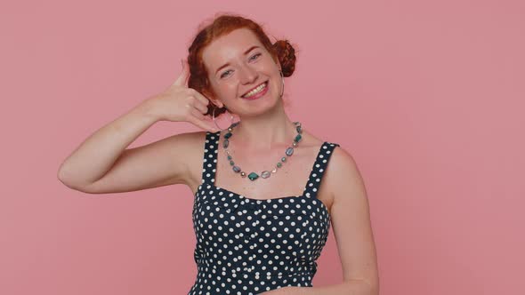 Red Hair Young Woman Seller Looking at Camera Doing Phone Gesture Like Says Hey you Call Me Back