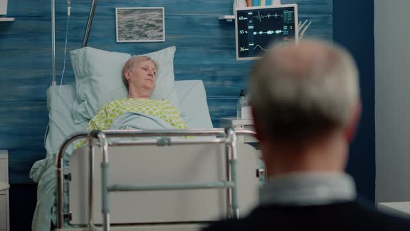 Woman with Disease Resting in Hospital Bed with IV Drip Bag