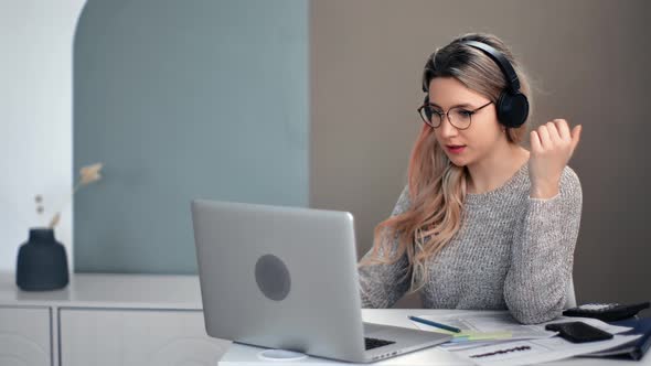 Modern Freelancer Woman in Headphones Talking Online Video Call Laptop