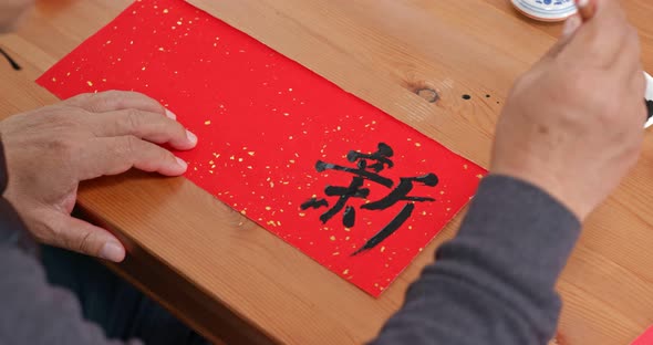 Man write chinese calligraphy for lunar new year