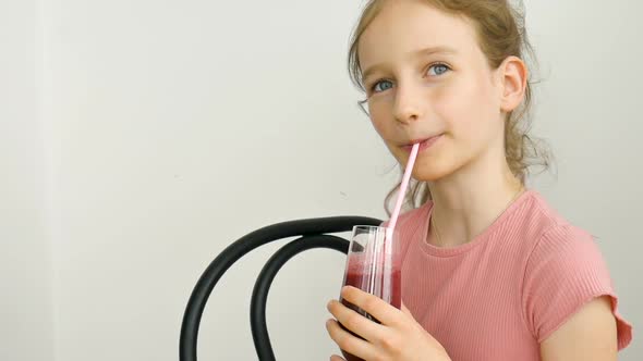 Sweet Little Girl Drinks Raspberry Smoothie and Smiles