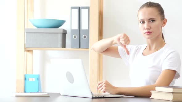 Thumbs Down Gesture By Woman at Work in Office