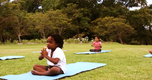 Group of kids performing yoga in park