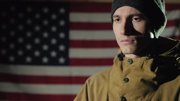 Side View of a Young Man Against the Background of the American Flag