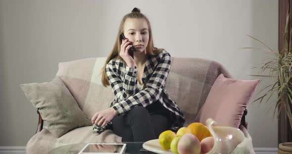 Stressed Caucasian Teenager Hanging Up Smartphone and Throwing Away Pillows. Portrait of Upset