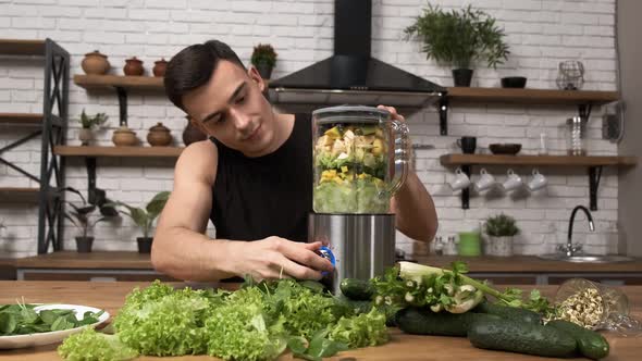 Making Green Juice at Home Athletic Man in Sportswear Blending Healthy Green Smoothie in a Blender