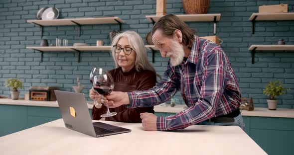 Cheerful Senior Couple Watching News on Laptop