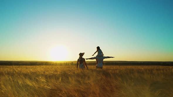 Family with Little Girl Walking in Field at Sunset