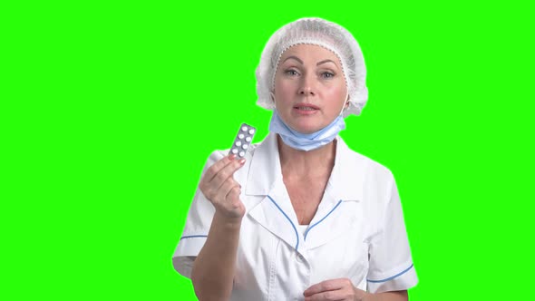 Pretty Female Doctor Holding Blister of Pills.