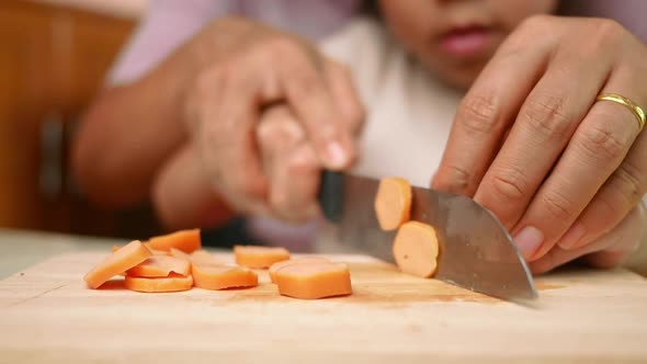 Close up of a knife cuts the sausage into small pieces.