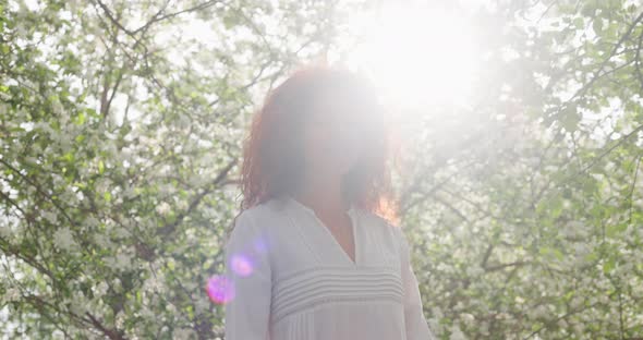 Woman Walking in a Blooming Garden