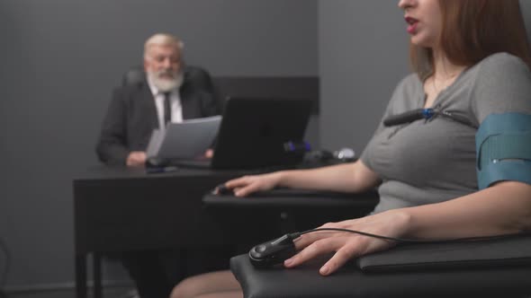 Young Girl Sitting in Chair with Pulse Sensors of Polygraph