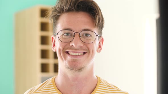 Portrait of a Young Clever Guy with Glasses Smiling at the Camera.