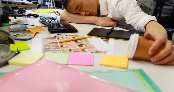 Male graphic designer sleeping at desk