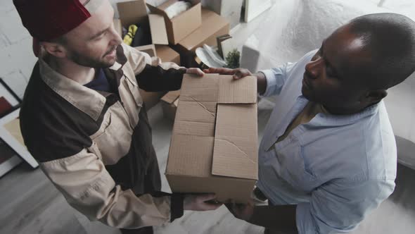 Moving Company Worker Handing Box to Homeowner