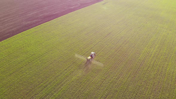 Aerial View of Farming Tractor Spraying on Field with Sprayer