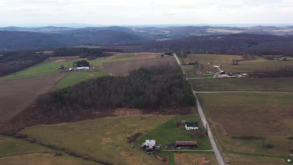 Flying over landscape in Pennsylvania covered in fall colors with small farms here and there