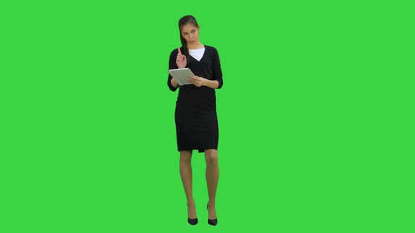 Pretty Business Woman Giving Presentation Using Digital Tablet on a Green Screen, Chroma Key