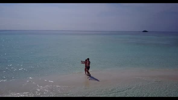 Man and woman suntan on paradise shore beach vacation by blue ocean and white sandy background of th