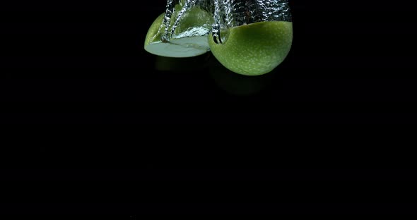 Granny Smith Apples, malus domestica, Fruits entering Water against Black Background, Slow Motion 4K