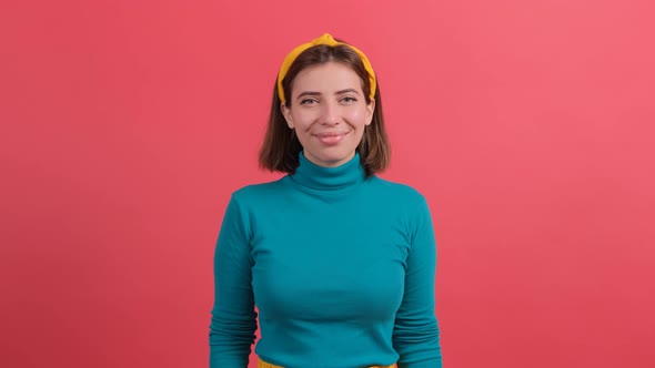 Pretty Girl Looking at Camera with a Smile Isolated Over Red Background