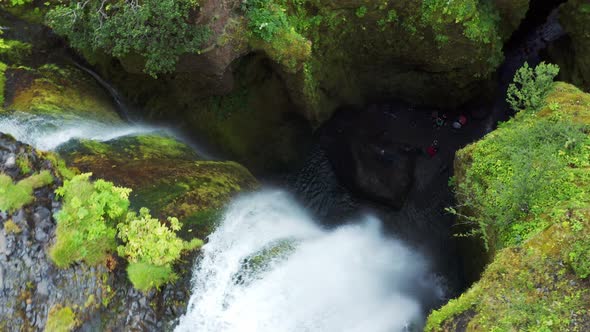 Descending into a Gljufrabui waterfall cave with Tourists down bellow - Iceland