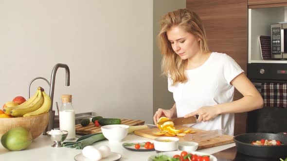 Pleasant Young Woman Preparing Dinner in a Kitchen Concept Cooking