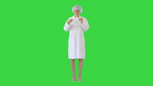 Wear the Mask! Female Doctor Wearing a Mask and Pointing Her Finger Up on a Green Screen, Chroma Key