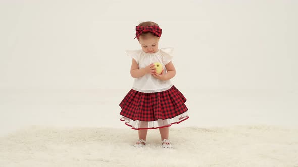 Little Girl in Plaid Headband is Holding Apple