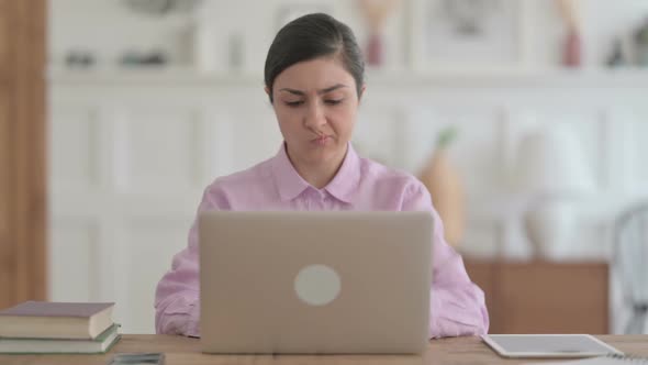 Indian Woman Thinking while Working on Laptop in Office