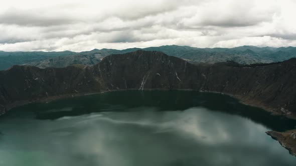 Quilotoa Volcanic Crater Lagoon With Tourists Enjoying Scenery In Ecuador - aerial drone shot