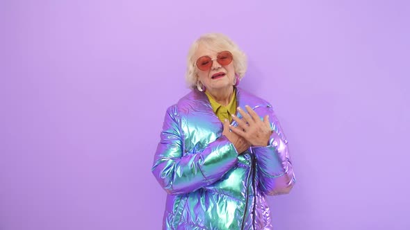 Modern Retired Woman Enjoys a Photo Shoot on Camera in a Studio, Isolated Background