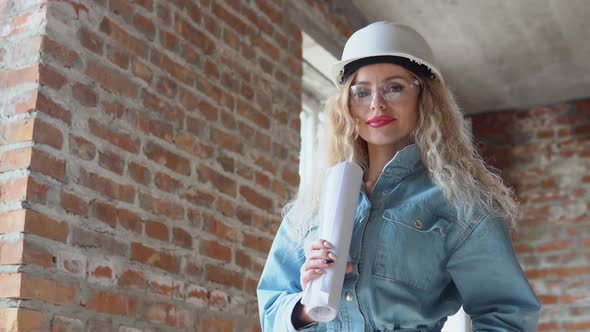 Female Architect Holding an Architectural Construction Plan While on the Construction Site
