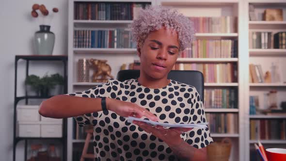 Dark Skinned Businesswoman Scattering Documents While Sitting in Office