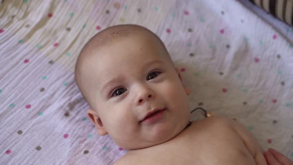 Little Naked Diaper Newborn Baby is Funny Smiling Lying at Back