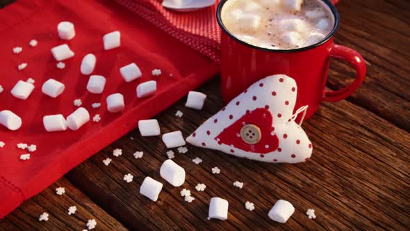 Coffee mug, marshmallow and napkin on a plank