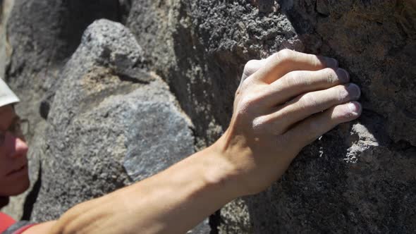 Detail of a young man rock climbing and grabbing a hold.