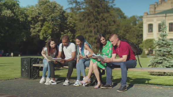 Joyful Multi Ethnic Students Meeting on Park Bench