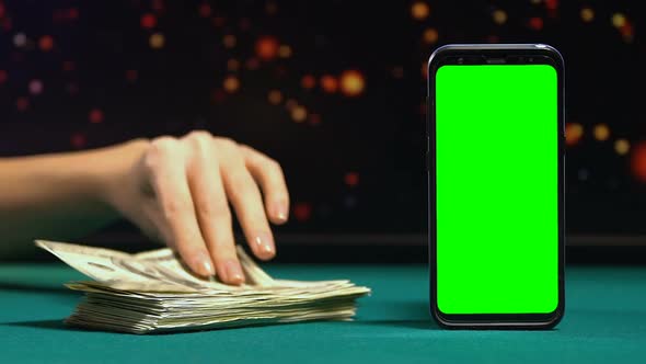 Woman Showing Hundred-Dollar Bill Near Green Screen Smartphone, Online Earnings