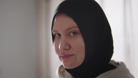 Young Woman in Hijab Looks in the Camera