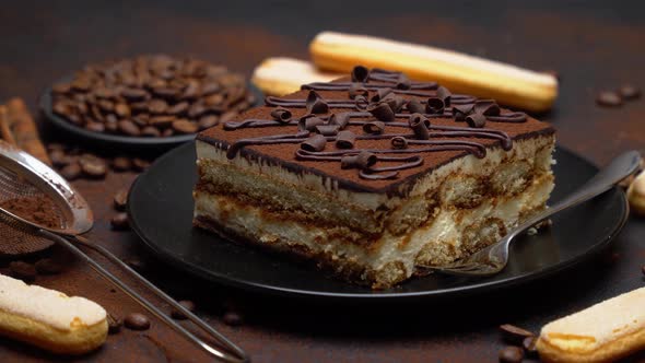 Portion of Traditional Italian Tiramisu dessert, savoiardi cookies and coffee beans