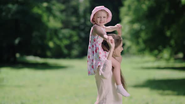 Family Fun. Mother And Daughter Playing And Laughing In Park