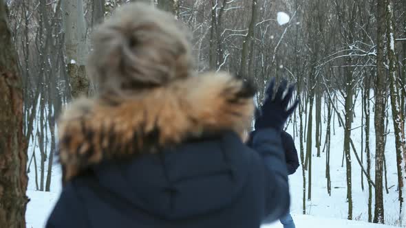 Couple Playing with Snow Boyfriend Throwing a Ball in Winter