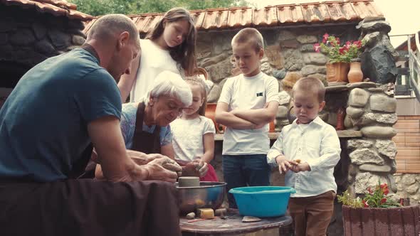 Grandparents with a Grandchildren Make Jug in Pottery