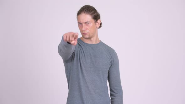 Handsome Man Pointing To Camera Against White Background