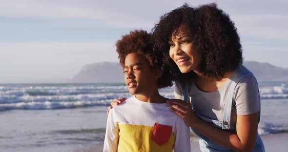 African american mother and her son embracing on the beach